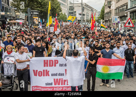 Partecipante di una manifestazione contro la politica del governo turco, portare bandiere del partito curdo HDP (il Partito democratico popolare), che leggere "HDP sono le persone e noi siamo il popolo!' e 'Stuttgart piattaforma HDP', come si sfila per le strade di Stoccarda, Germania, 12 settembre 2015. Alcuni 2.000 curdi e il governo turco critici sono scesi in piazza per protestare contro l'escalation della tensione nel loro paese dopo la Turchia ha effettuato un ondata di scioperi contro il Partito dei Lavoratori del Kurdistan (PKK) bersagli nel nord Iraq. Foto: Wolfram Kastl/dpa Foto Stock