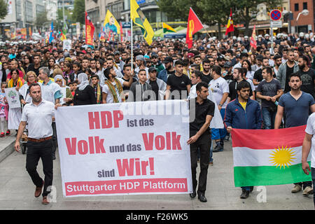 Partecipante di una manifestazione contro la politica del governo turco, portare bandiere del partito curdo HDP (il Partito democratico popolare), che leggere "HDP sono le persone e noi siamo il popolo!' e 'Stuttgart piattaforma HDP', come si sfila per le strade di Stoccarda, Germania, 12 settembre 2015. Alcuni 2.000 curdi e il governo turco critici sono scesi in piazza per protestare contro l'escalation della tensione nel loro paese dopo la Turchia ha effettuato un ondata di scioperi contro il Partito dei Lavoratori del Kurdistan (PKK) bersagli nel nord Iraq. Foto: Wolfram Kastl/dpa Foto Stock