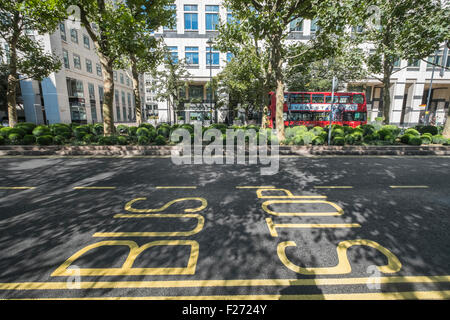 Fermata bus iscrizioni su una strada di Canary Wharf, London, England Regno Unito Foto Stock