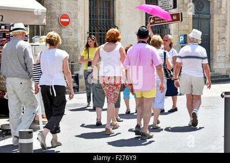 La guida del tour tiene un ombrello dai colori vivaci come marcatore per consentire a gruppi di turisti del Regno Unito di seguire la passeggiata turistica estiva ad Avignone in Francia Foto Stock