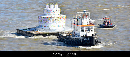Torta di compleanno con candele close up che viene trainato dal rimorchiatore lungo il fiume Tamigi per eBay ventesimo compleanno Londra Inghilterra REGNO UNITO Foto Stock