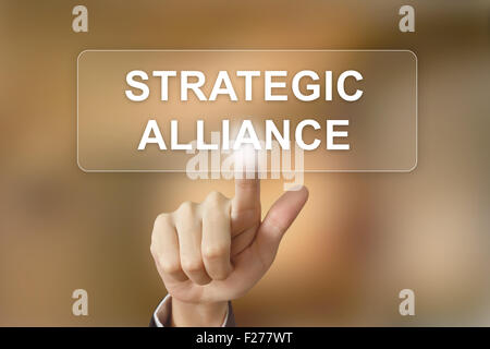 Business mano spingendo alleanza strategica pulsante sullo sfondo sfocato Foto Stock