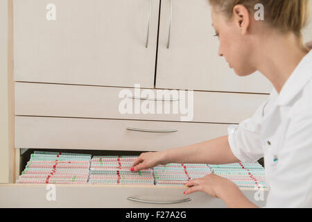 Medico donna ricerca per i record medici in un cassetto, Monaco di Baviera, Germania Foto Stock