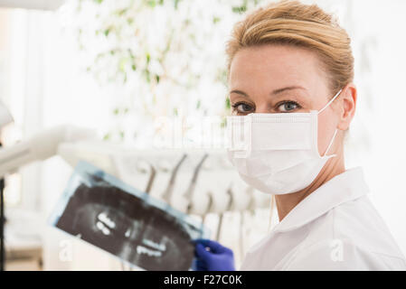 Dentista femmina tenendo un X-ray relazione, Monaco di Baviera, Germania Foto Stock