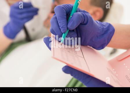 Assistente dentale la scrittura sulla scheda Indice, Monaco di Baviera, Germania Foto Stock