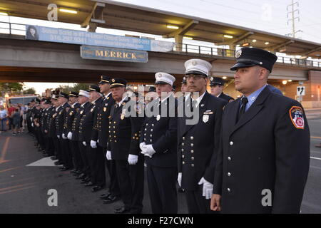 Merrick, New York, Stati Uniti d'America. 11 settembre 2015. Vigili del fuoco da Merrick e New York City stand in linea durante Merrick cerimonia commemorativa per Merrick vigili del fuoco volontari e residenti che sono morti a causa di 9/11 attacco terroristico a New York Torri Gemelle. Ronnie Ex-Chief E. Gies, di Merrick F.D. e FDNY Squad 288, e Ex-Captain Brian E. Sweeney, di Merrick F.D. e FDNY Rescue 1, morì di rispondere agli attacchi dell'11 settembre, 2001. Credito: Ann e Parry/Alamy Live News Foto Stock