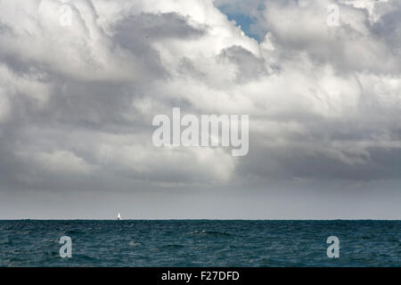 Il mare e il cielo, barca a vela sul lontano orizzonte Foto Stock