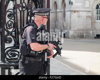 Un lone poliziotto armato con una macchina semiautomatica sulla pistola a guardia della Londra Whitehall Foto Stock