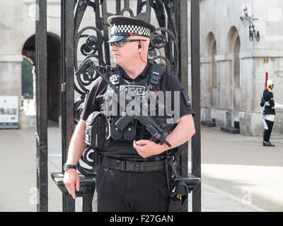 Un lone poliziotto armato con una macchina semiautomatica sulla pistola a guardia della Londra Whitehall Foto Stock