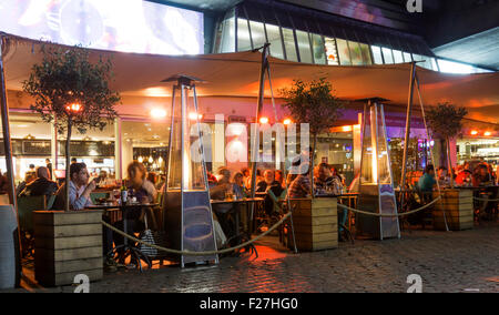 Persone mangiare fuori del National Film Theatre, sotto il ponte di Waterloo, sul London South Bank. Foto Stock