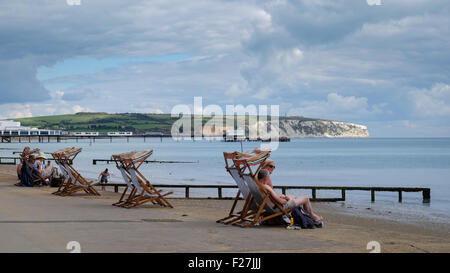 Persone su rilassanti sedie a sdraio sul lago spiaggia sull'Isola di Wight in Inghilterra Foto Stock