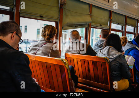 I passeggeri seduti su legno di mogano panche all'interno di un automobile della via a New Orleans, LA Foto Stock