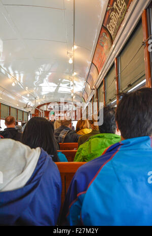 I passeggeri seduti sul classico panche di legno a bordo del famoso St. Charles Streetcar in New Orleans, LA Foto Stock