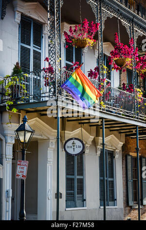 St. Ann Inn, un creolo Townhouse balconi in ferro battuto, fiori appesi e bandiera arcobaleno, nel Quartiere Francese di New Orleans, LA Foto Stock