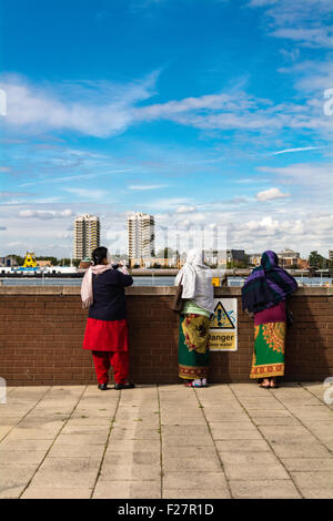 Donne asiatiche che indossano kameez e dupatta shalwar, in piedi davanti al terminal dei traghetti di Woolwich a Londra, Regno Unito Foto Stock