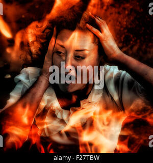 Una donna che guarda attraverso le fiamme, urlando Foto Stock