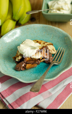 Una banana e cioccolato budino di pancake con crema. 'Small' piastra pasto sweet food UK Foto Stock