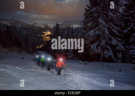 Chi pratica lo sci alpinismo arrampicata sulla montagna innevata con testa torce, Val Gardena, Trentino-Alto Adige, Italia Foto Stock