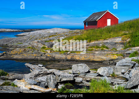Red Timber house presso la costa rocciosa del Mare di Norvegia vicino a BUD, Kommune Fraena, Romsdal penisola, Norvegia Foto Stock