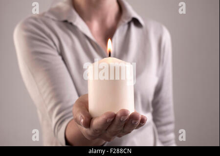 Donna che mantiene la masterizzazione di candela in mano, Baviera, Germania Foto Stock