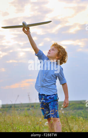 Ragazzo gettando aereo nel campo Foto Stock