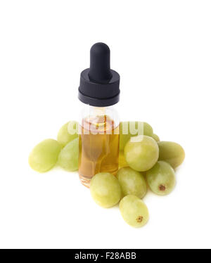 Olio di semi di uva essenza in una piccola bottiglia con una pipetta, circondato con il bianco più uva da tavola, composizione isolata o Foto Stock