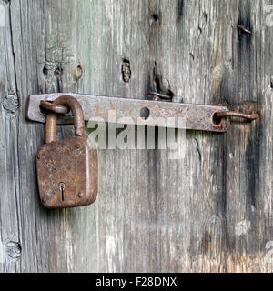 Vecchie porte in legno bloccato con lucchetto arrugginito Foto Stock