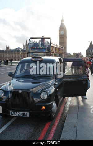 Un Black Cab si ferma sul Westminster Bridge a scendere i passeggeri Foto Stock