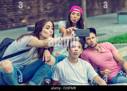 Guidatore di skateboard amici su per le scale, fatta selfie foto Foto Stock