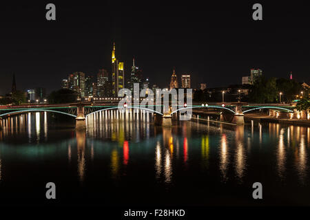 Ponte sul fiume con skyline illuminata di notte, Francoforte, Germania Foto Stock