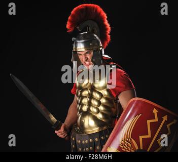 Arrabbiato legionario soldato con una gladius e protezioni Foto Stock