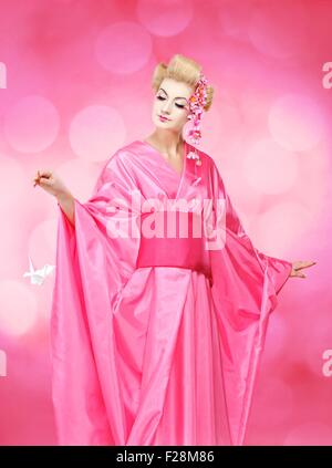 Bella geisha con un uccello origami Foto Stock