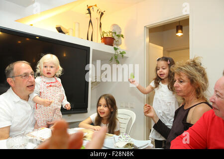 Famiglia seduti attorno a un tavolo per una festa ebraica pasto sulla Pasqua (traslitterato come Pesach o Pesah) Foto Stock