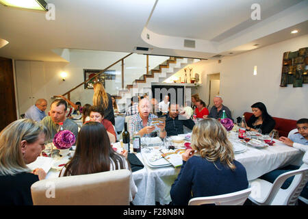 Famiglia seduti attorno a un tavolo per una festa ebraica pasto sulla Pasqua (traslitterato come Pesach o Pesah) Foto Stock