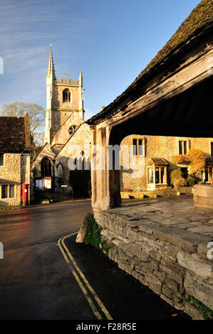 La chiesa di Sant'Andrea Castle Combe, visto da accanto alla croce di mercato nel centro del villaggio. Foto Stock