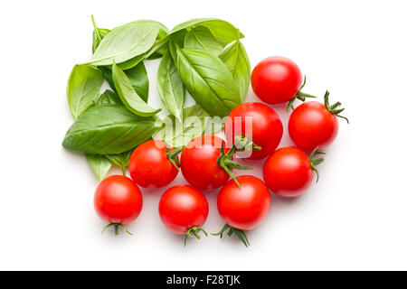 Pomodori e basilico foglie su sfondo bianco Foto Stock