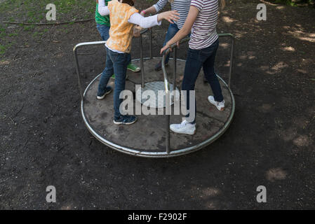 Bambini divertirsi su una giostra nel parco giochi, Monaco di Baviera, Germania Foto Stock