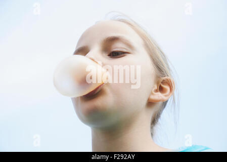 Ragazza soffiando la gomma da masticare bolla, Baviera, Germania Foto Stock