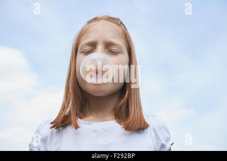 Ragazza soffiando la gomma da masticare bolla, Baviera, Germania Foto Stock