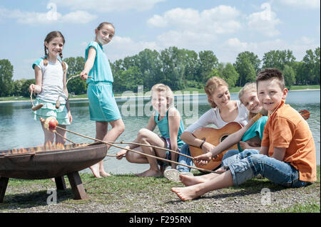 Gruppo di amici preparare le salsicce sul fuoco, Baviera, Germania Foto Stock