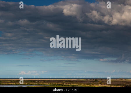 Cielo drammatico sulla spiaggia Cley North Norfolk distanti le turbine eoliche Foto Stock