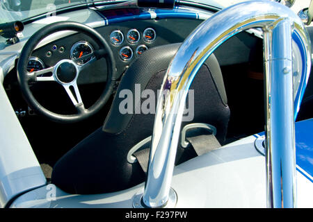 Interno di un vintage auto sportiva che mostra il volante, cruscotto, sedile conducente e roll-over protection. Foto Stock