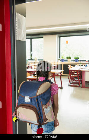 Vista posteriore di una scolaretta entrando in Aula, Monaco di Baviera, Germania Foto Stock