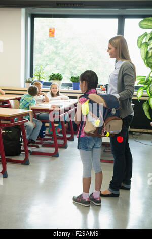 Insegnante femmina introducendo un nuovo compagno di classe in aula, Monaco di Baviera, Germania Foto Stock