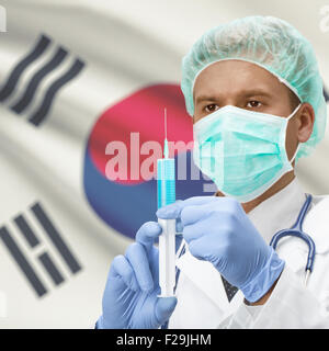 Medico con una siringa in mani e bandiera sulla serie di sfondo - Corea del Sud Foto Stock