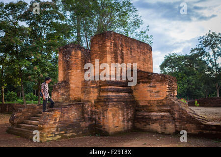Un villager sta posando per una foto al tempio di Gedong i in Muara Jambi templare Compounds a Muaro Jambi, Jambi, Indonesia. Foto Stock