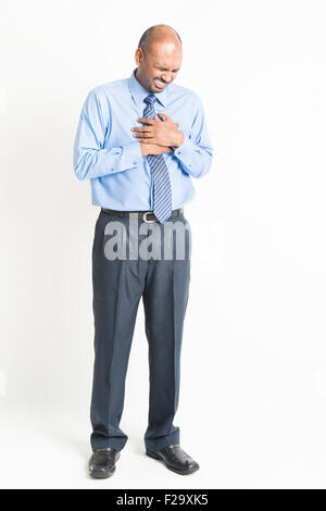 A piena lunghezza Indian business man heartache, premendo sul petto con espressione dolorosa, su sfondo semplice Foto Stock