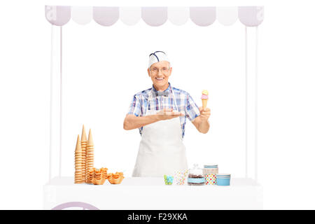 Coppia di gelato venditore di trattenimento di un cono gelato in una mano e rivolti verso di essa con gli altri Foto Stock