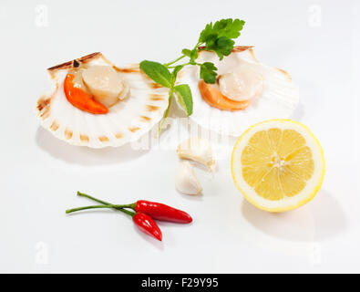 Cappesante e limone su sfondo bianco Foto Stock