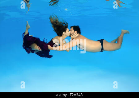 L uomo e la donna baciare sotto acqua, fasihon subacquea in piscina, Odessa, Ucraina Foto Stock